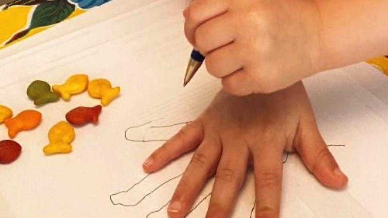 A child tracing their hand.