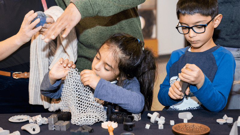 Two young learners experiment with building at an engineering demonstration