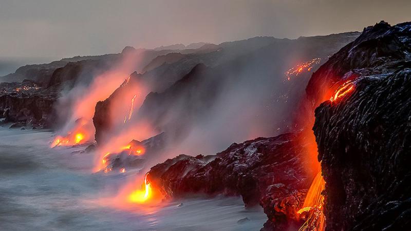 Lava flows from volcanoes in Hawaii meeting the ocean.