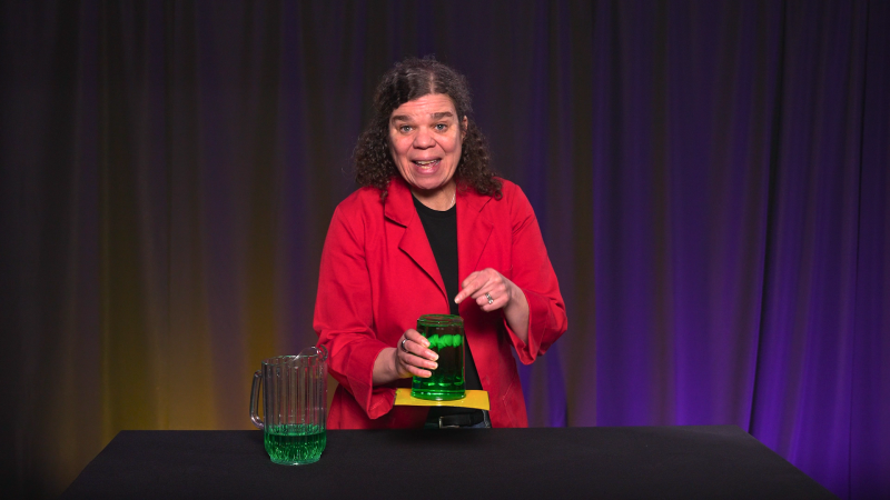 Jeannine holds a glass of water upside down without it spilling