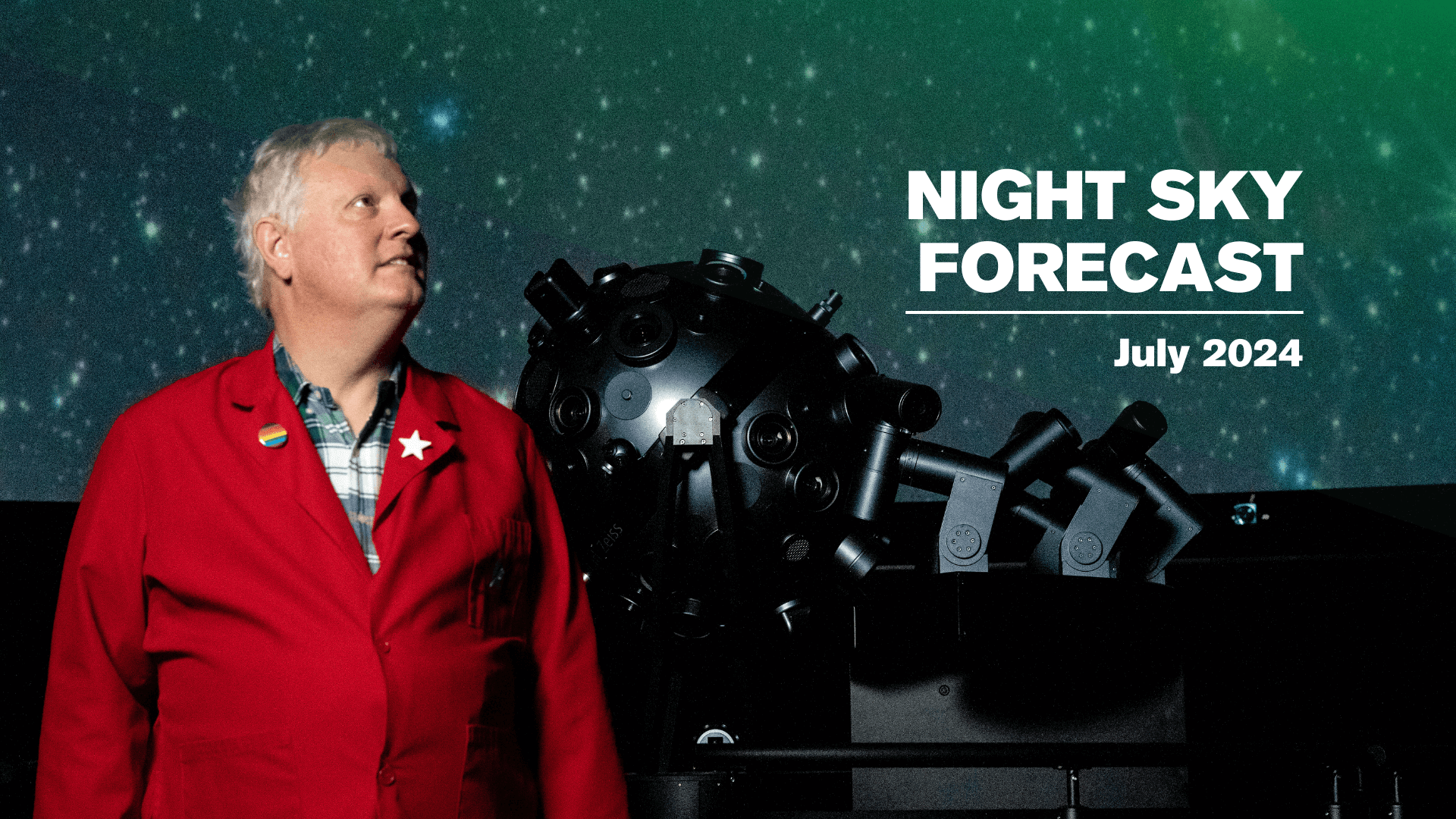 Chuck Wilcox in a red lab coat standing in front of a planetarium projector