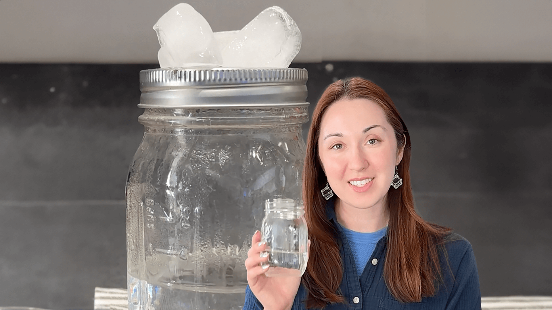 Alex Dainis holding a jar of water, in front of a jar with ice cubes on top