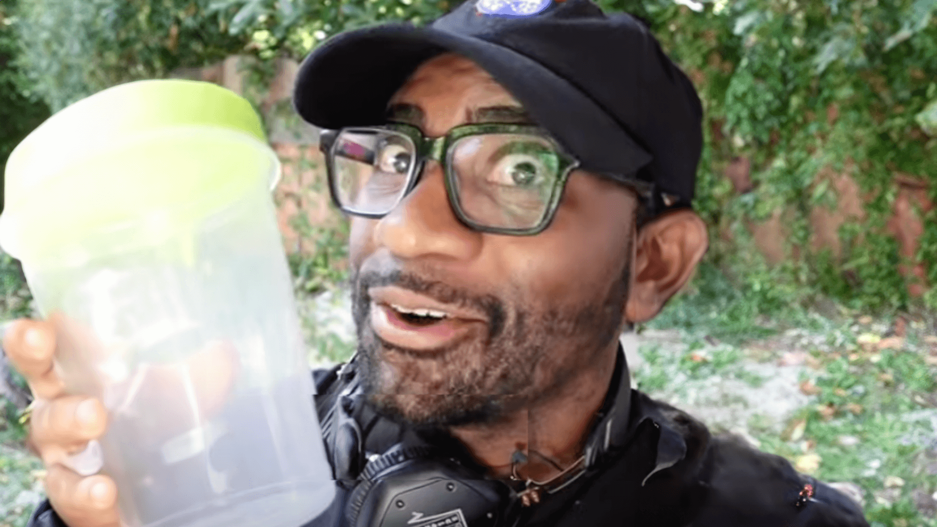 Maynard Okereke smiling holding a homemade compost container