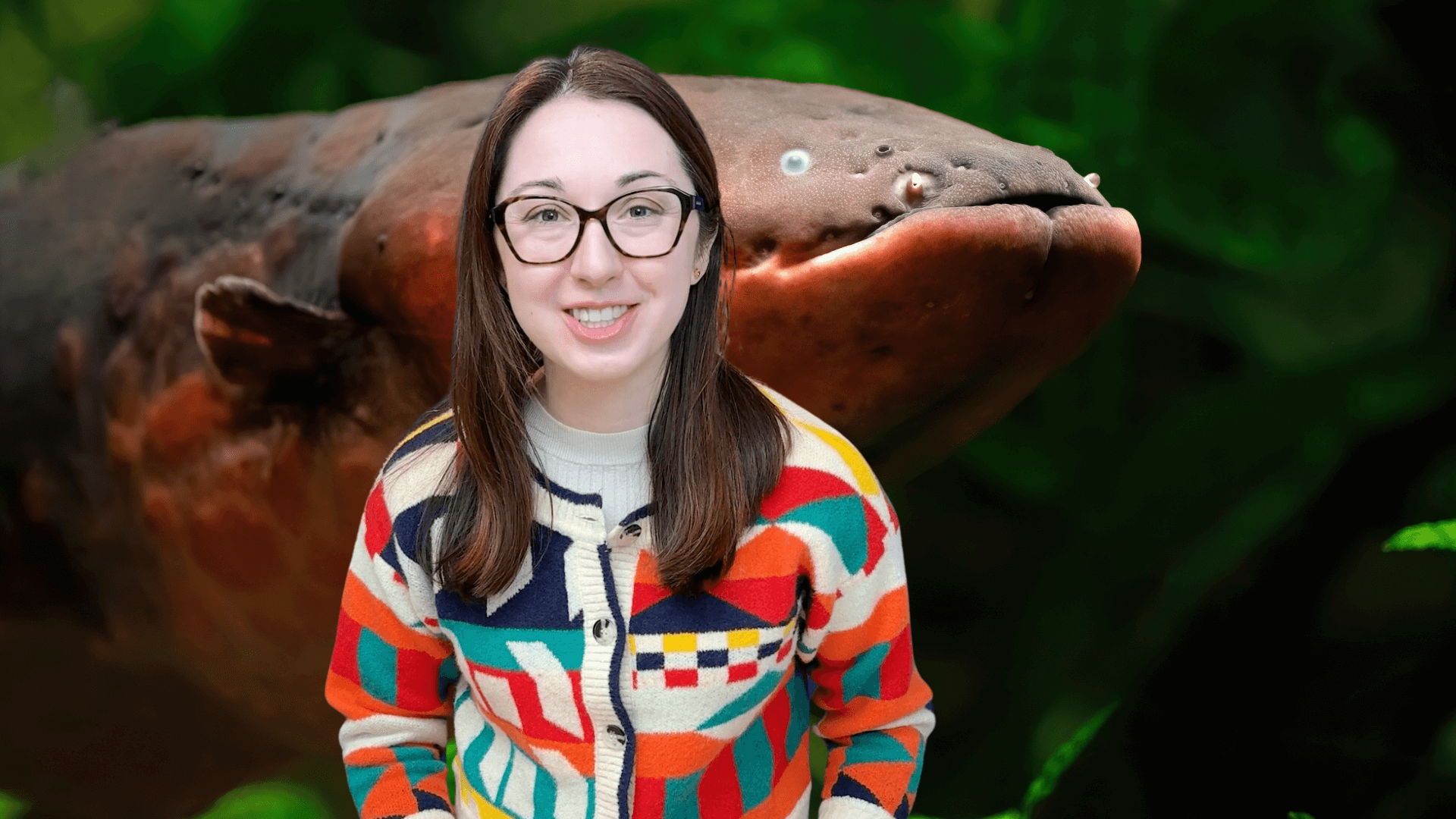 Alex Dainis smiling in front of an eel