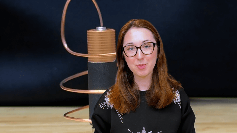 Alex Dainis in front of a battery with copper wire