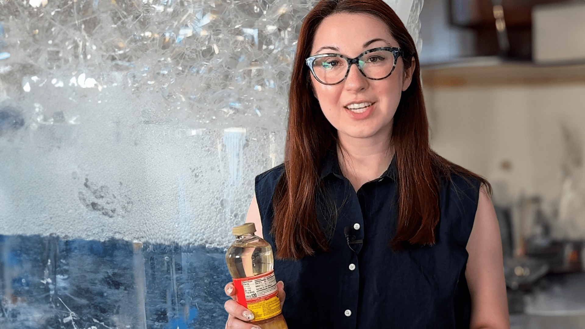 Alex Dainis in front of a glass filled with bubbles