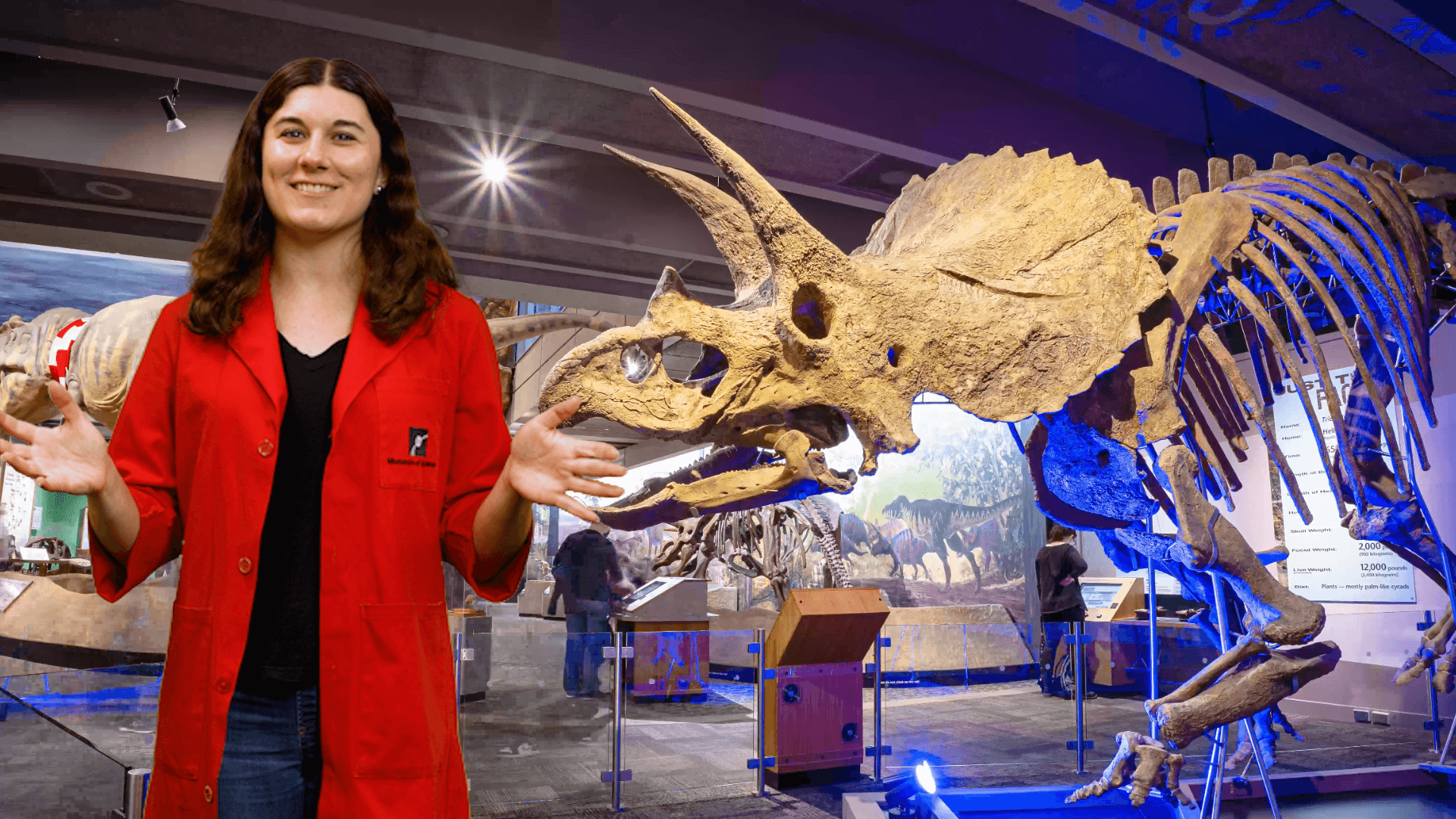 Becca standing in front of a triceratops skeleton