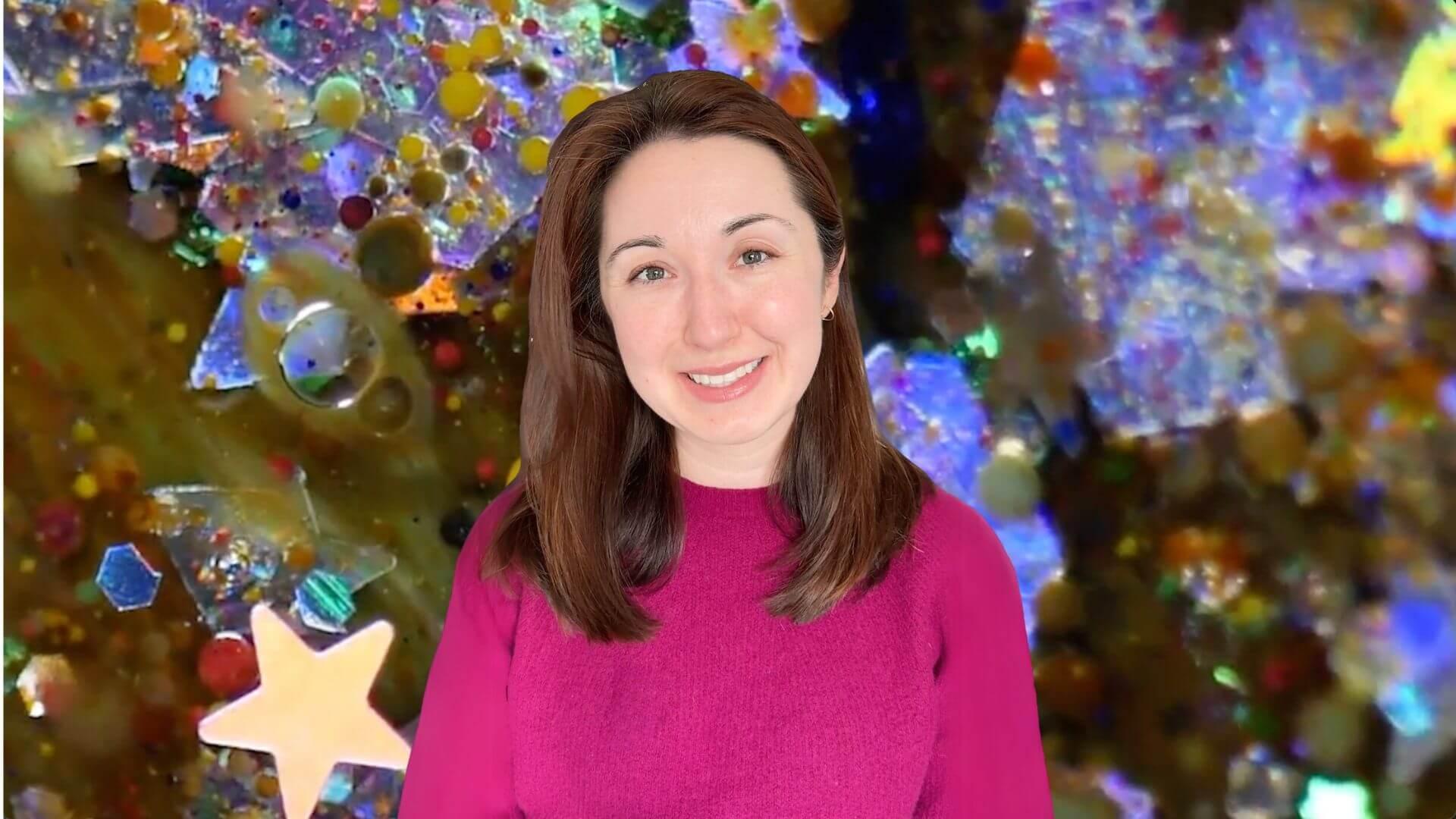 Alex Dainis in front of an image of glitter