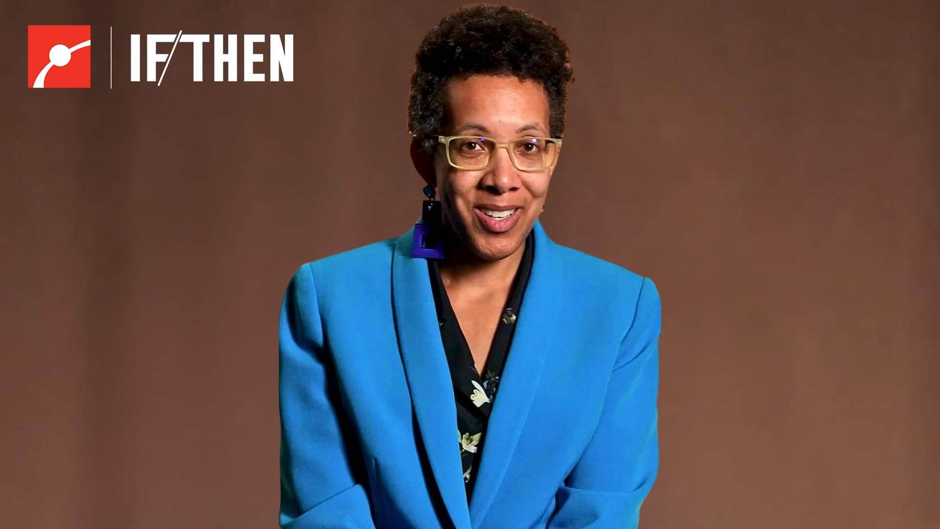 Kris Dorsey smiles at the viewer in a bright blue suit against a warm brown background