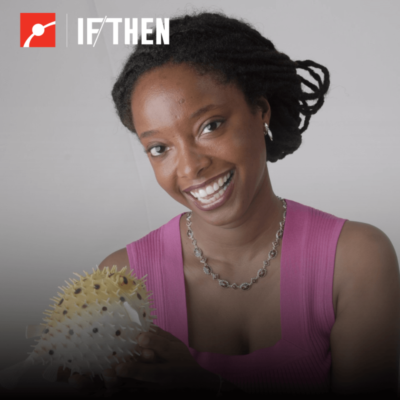 Dr. Lekelia (Kiki) Jenkins smiling at the viewer holding a model puffer fish