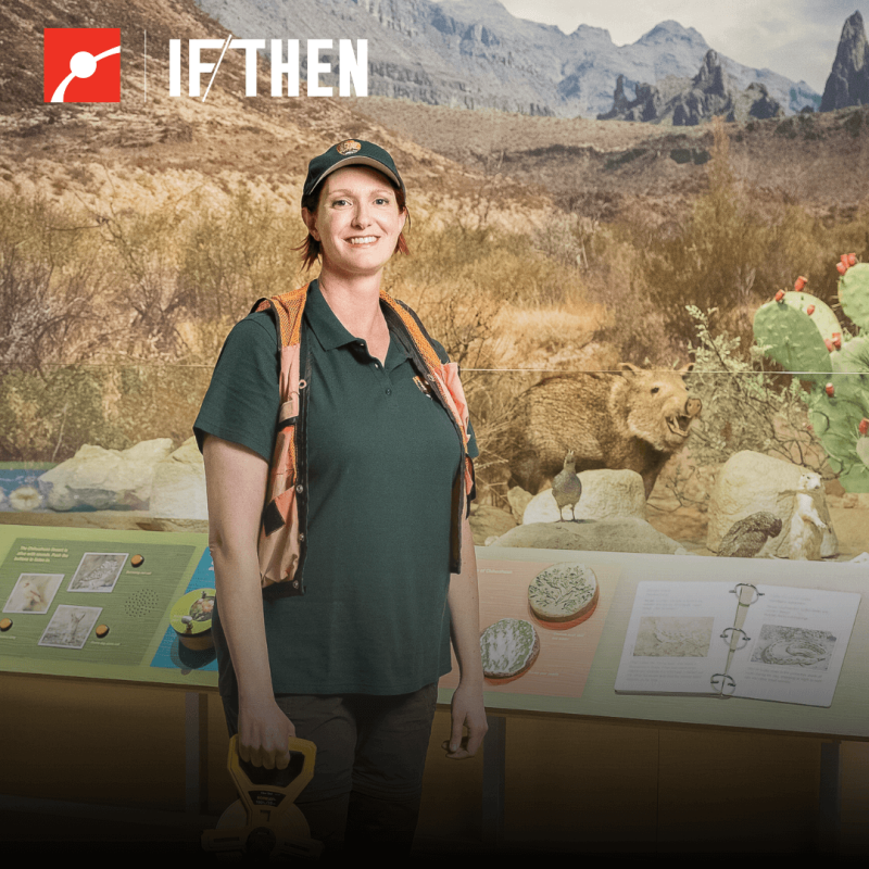 Sam Wynns stands in front of a nature exhibit while smiling at the viewer.